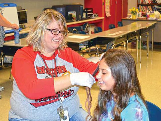 Alesha-Pegg-chalks-the-hair-of-third-grader-Brooklyn-MasonWEB